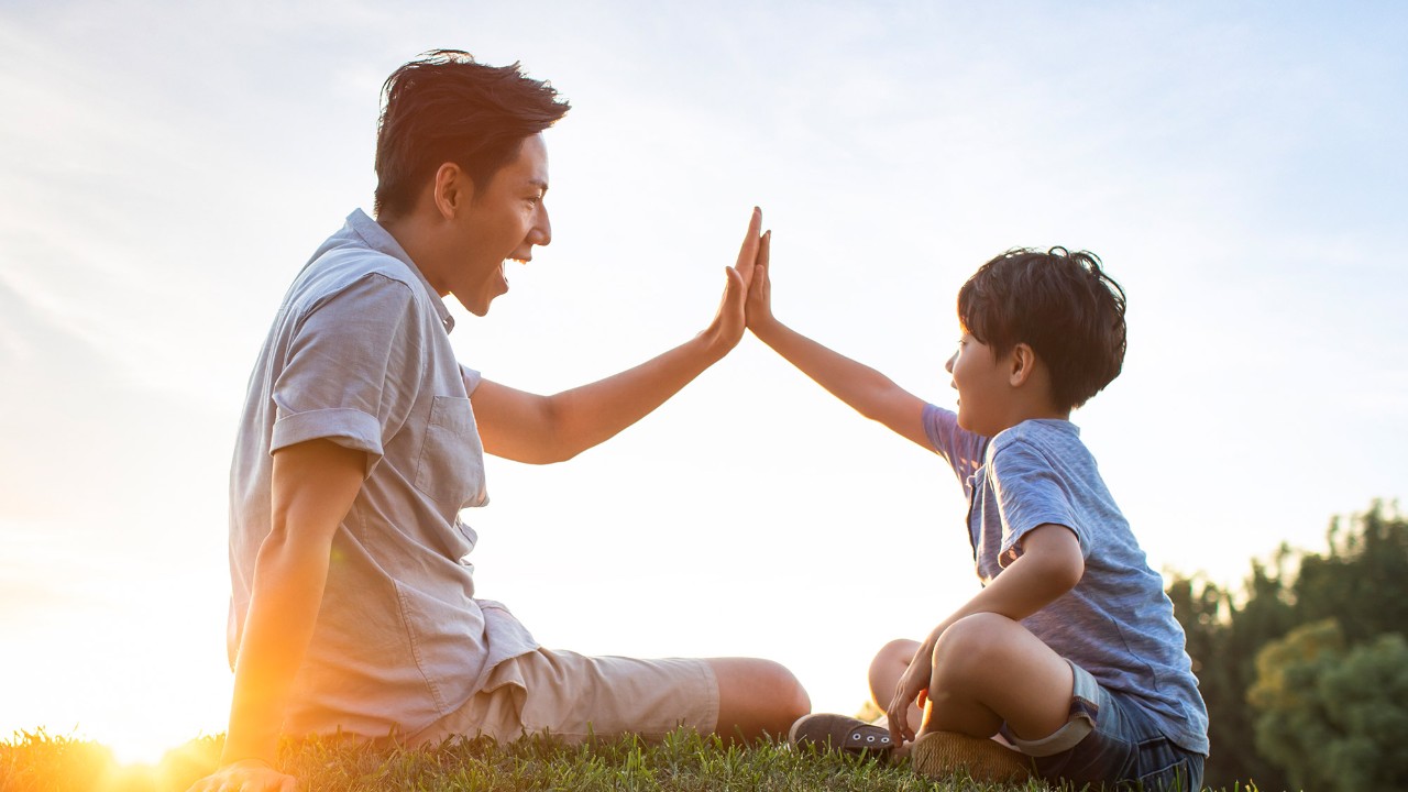 little brother is giving a high five to his brother; image used for HSBC Macau Offers Landing page.