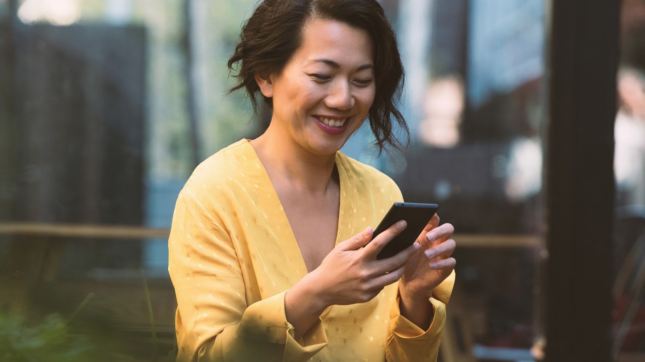 a woman is using mobile phone; image used for hsbc macau ways to bank page