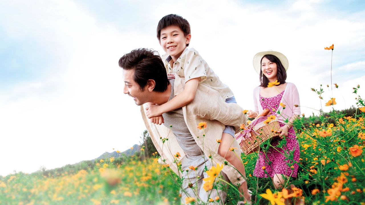一個家庭正在公園裡賞花; 圖片用於澳門滙豐滙康保險計劃頁面